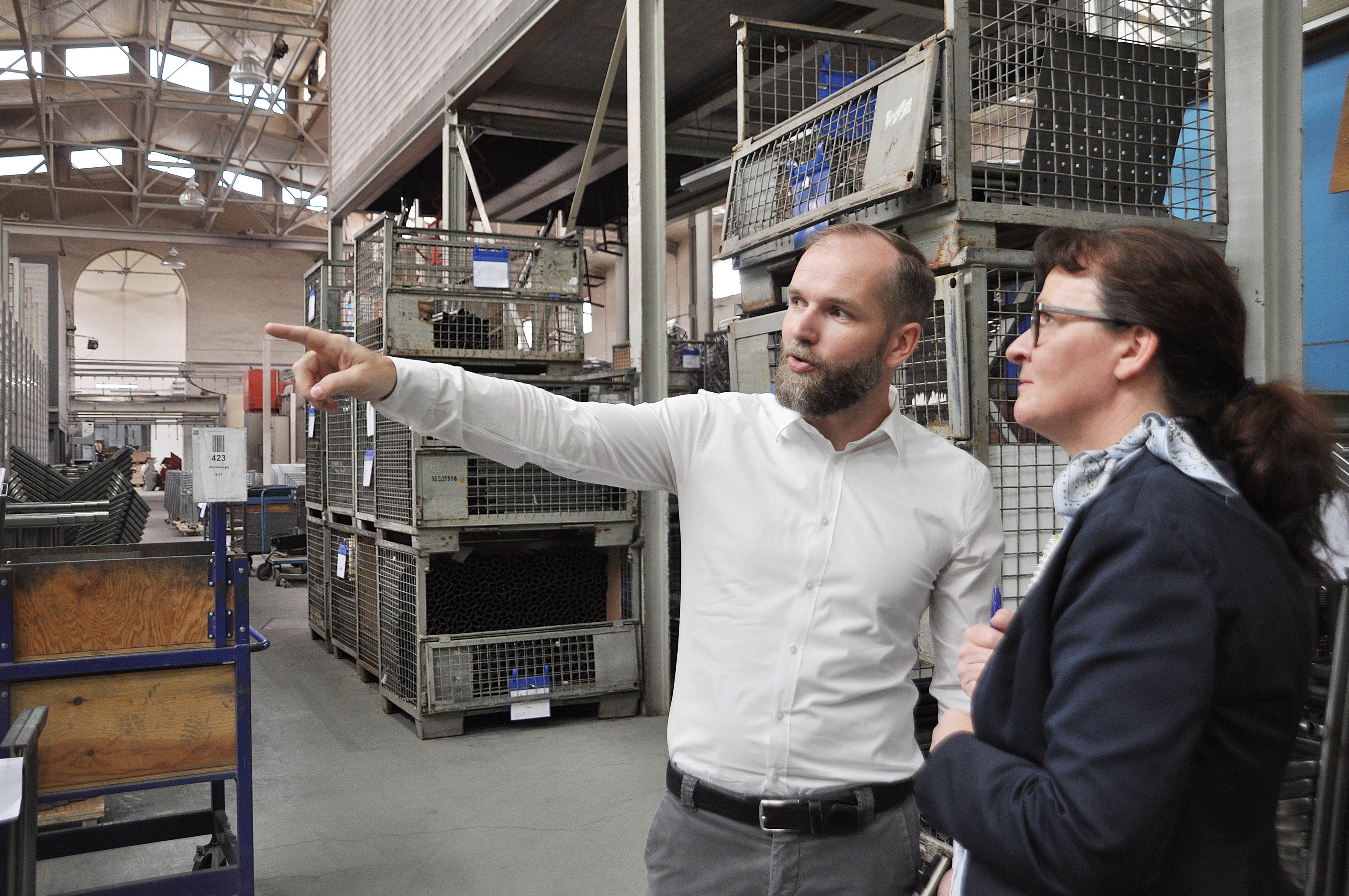 Vico Bachmann führt Kathrin Gantz von der Wirtschaftsförderung der Lutherstadt Eisleben durch die Werkhallen